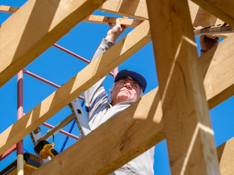 Senior,Gray-haired,Builder,Collects,The,Frame,Of,A,Wooden,Country